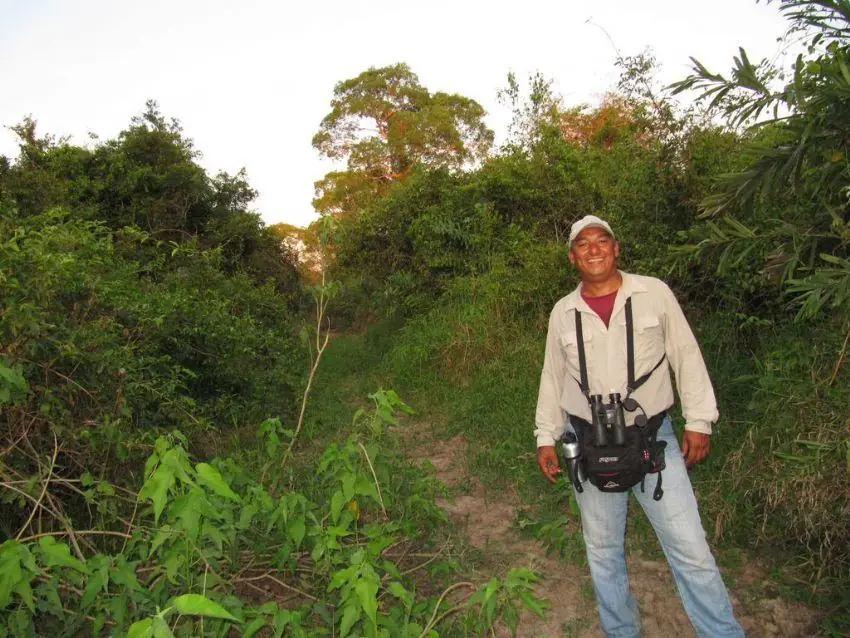Fisher Sousa with binoculars on a forest trail