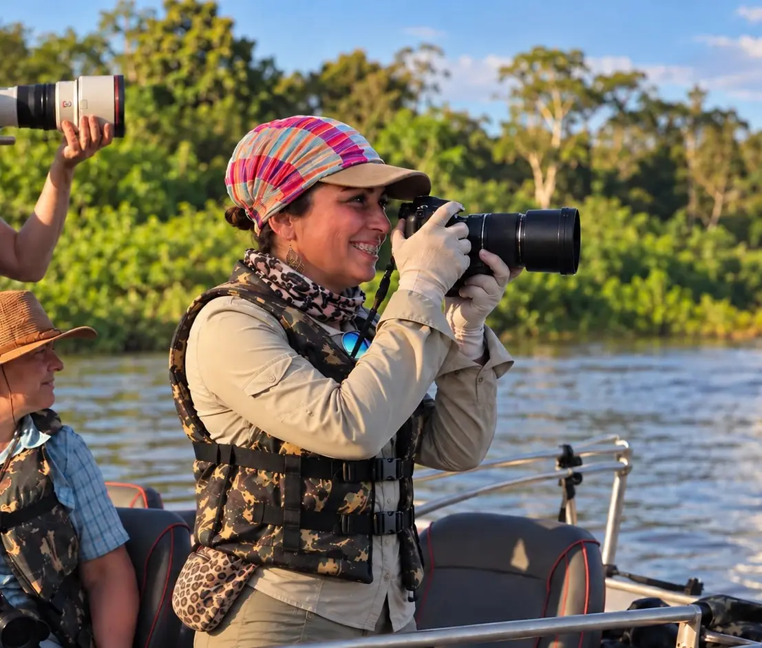 Patrícia Angel photographing wildlife from a boat on the river